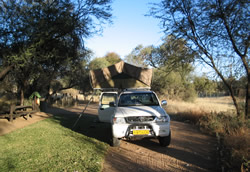 De auto en tent op de camping van de Okanhandja Lodge